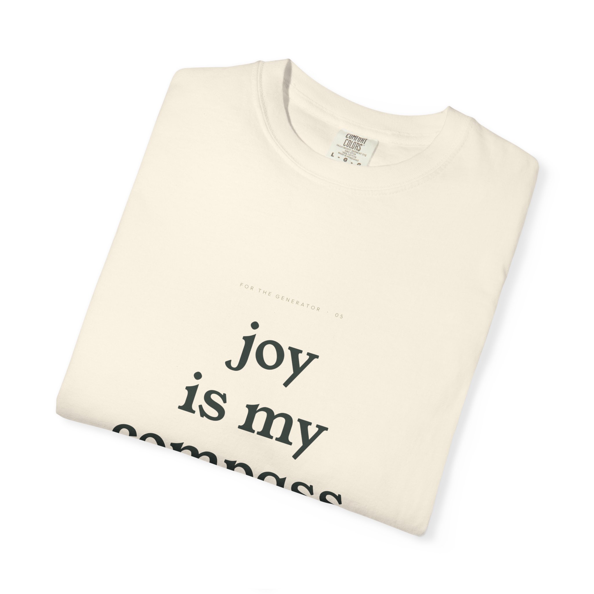 Cream-colored t-shirt folded, showing large black text reading 'joy' on the front