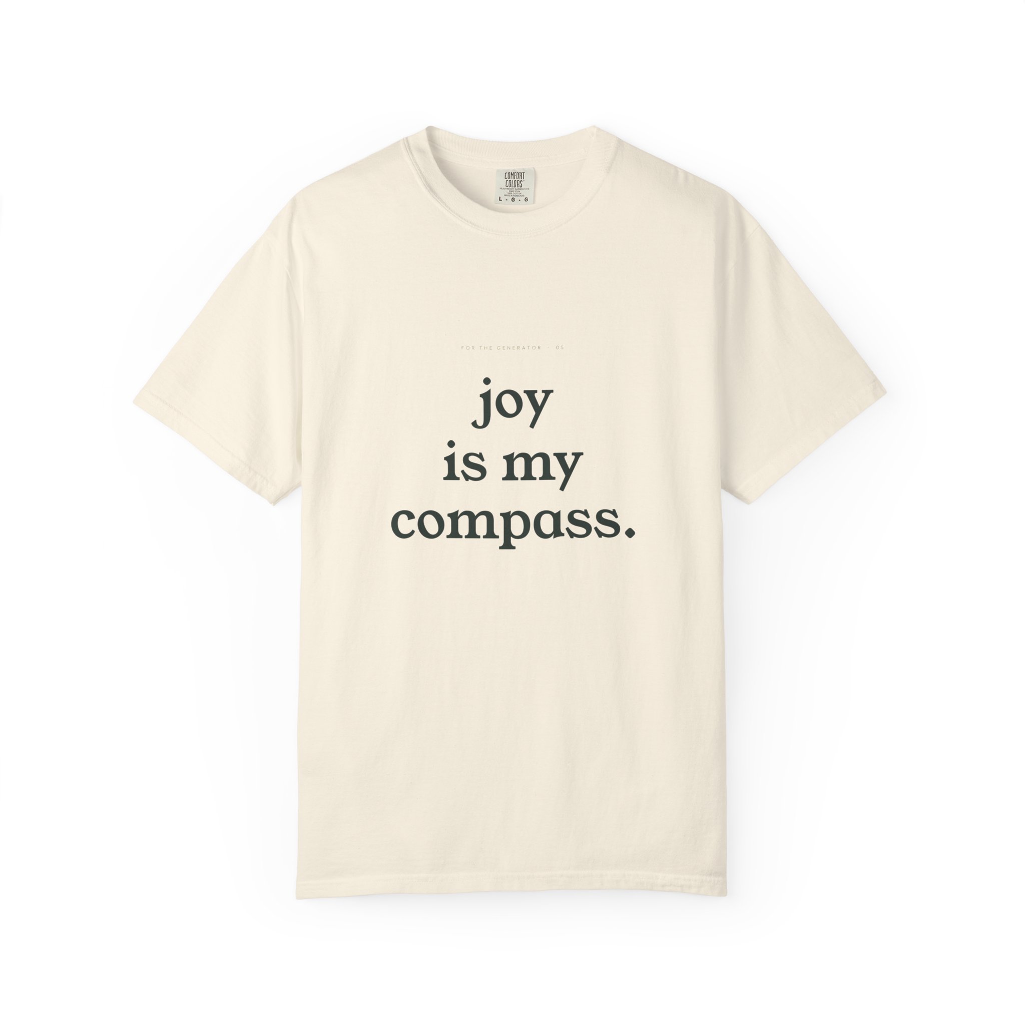 Cream-colored T-shirt with the bold black text 'joy is my compass' displayed on the front.